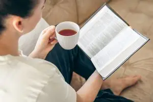Woman reading the Bible with a cup of coffee-peaceful morning devotional to start the workday