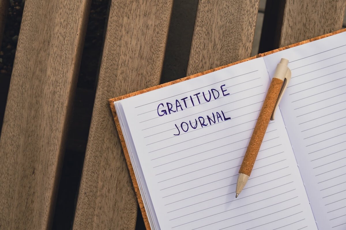 Open gratitude journal with a pen resting on its pages, symbolizing mindfulness, thankfulness, and taking time to reflect on God’s goodness.