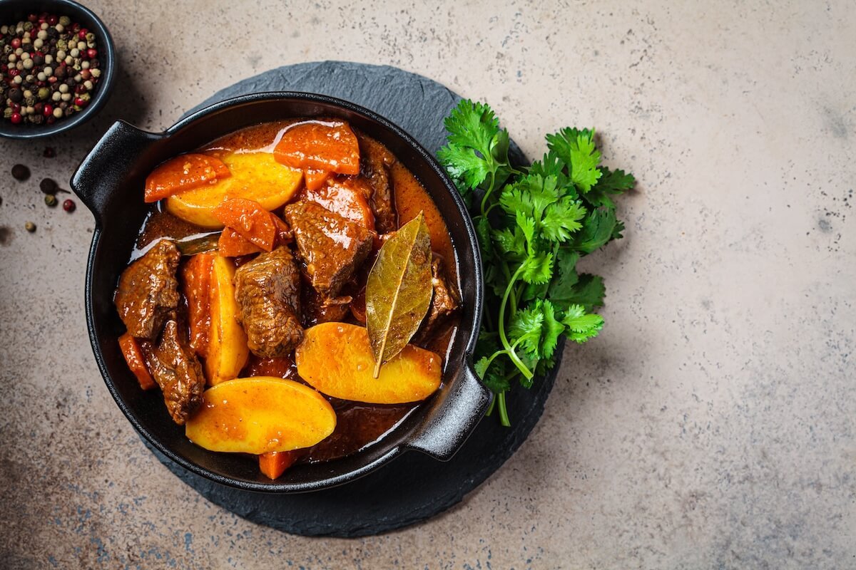 Bowl of hearty beef stew with tender beef, carrots, potatoes, and fresh herbs