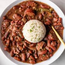 Bowl of red beans and rice with smoked sausage and green onions on top