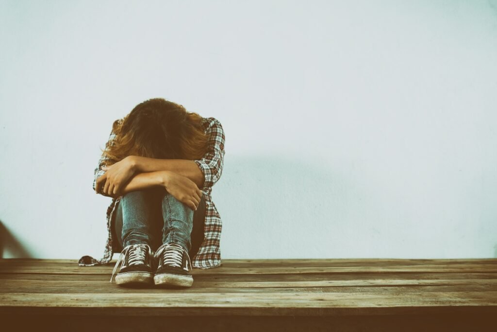 Woman sitting alone, dealing with emotional trauma.