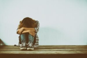 Woman sitting alone, dealing with emotional trauma.