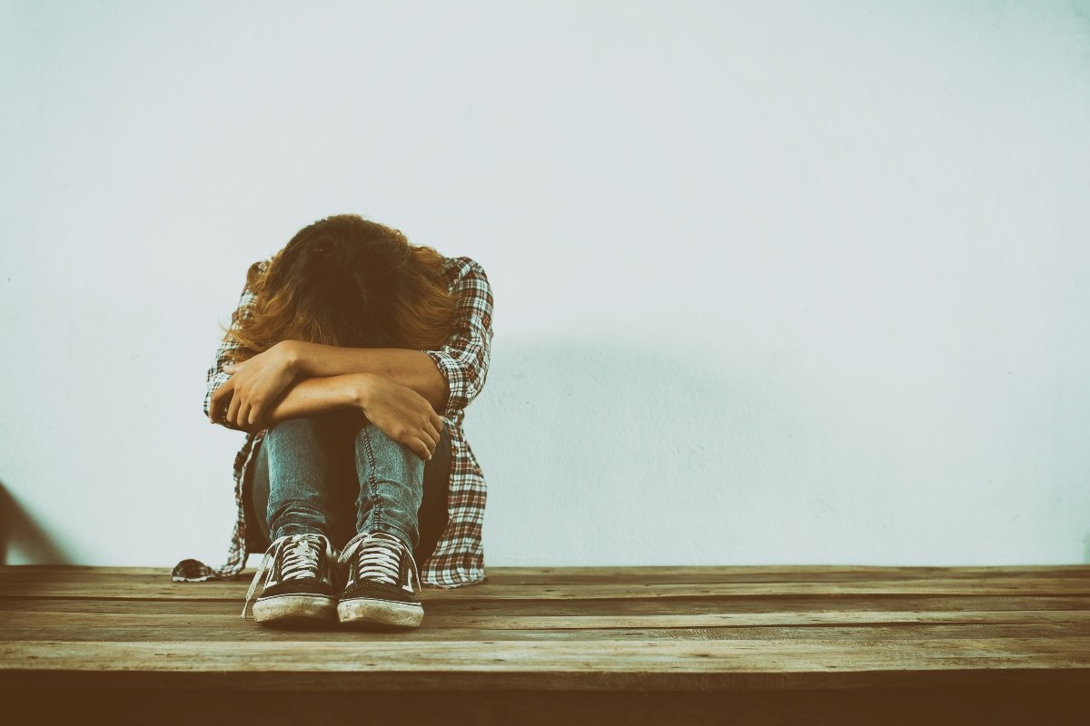 Woman sitting alone, dealing with emotional trauma.