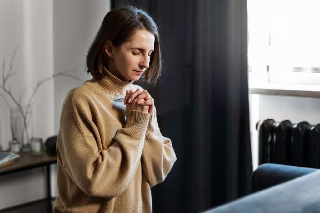 Woman praying at home while waiting on God for healing