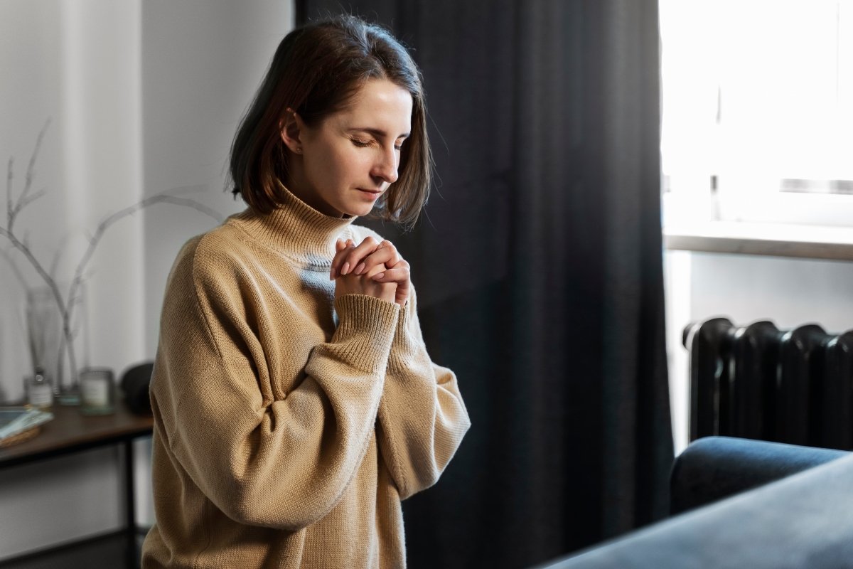 Woman praying at home while waiting on God for healing