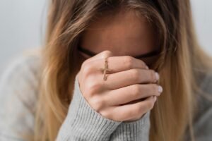 Young woman praying to God for healing.
