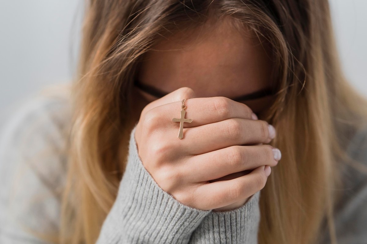 Young woman praying to God for healing.