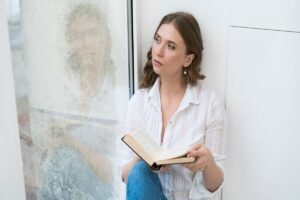 Woman reading the Bible by a window