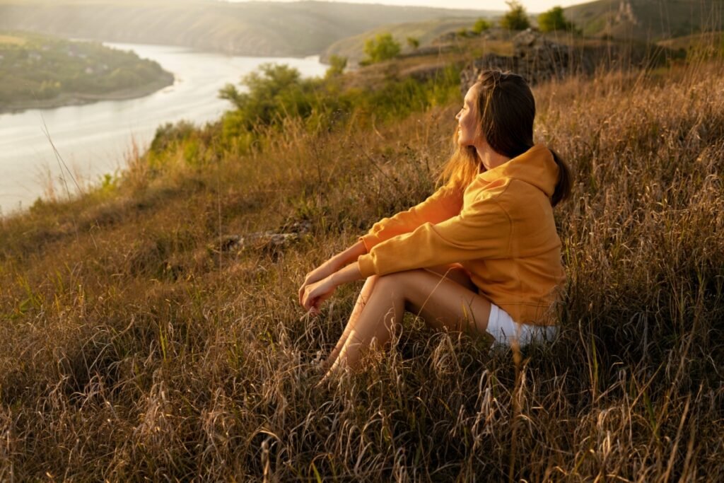 Woman sitting quietly by a lake in nature