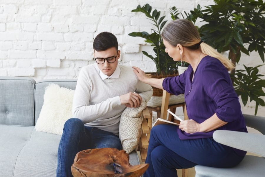 Therapist comforting a man during a session.