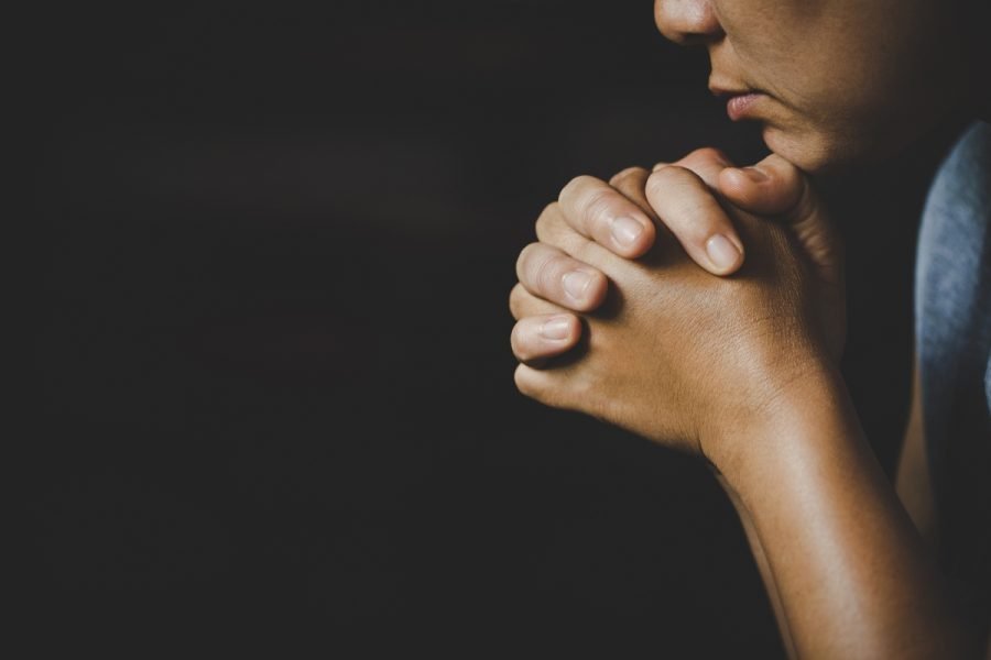 Woman rebuilding faith through prayer.