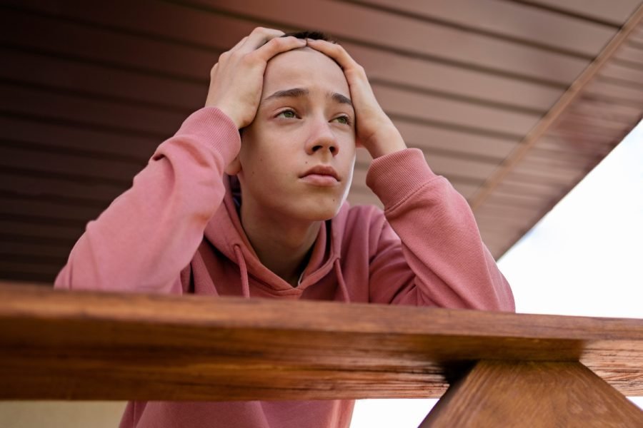 Young person struggling with anxiety and social pressure.